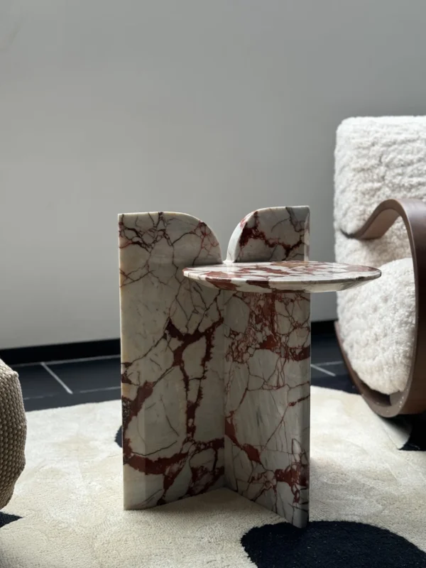 Red Veined Marble Geometric Side Table with Round Top in red — in a room setting