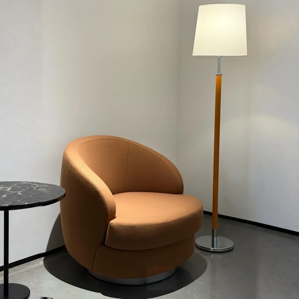 Curved Caramel Fabric Swivel Lounge Chair on Slim Base in rust — front view