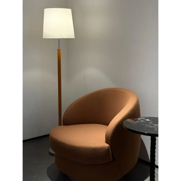 Curved Caramel Fabric Swivel Lounge Chair on Slim Base in rust — in a room setting