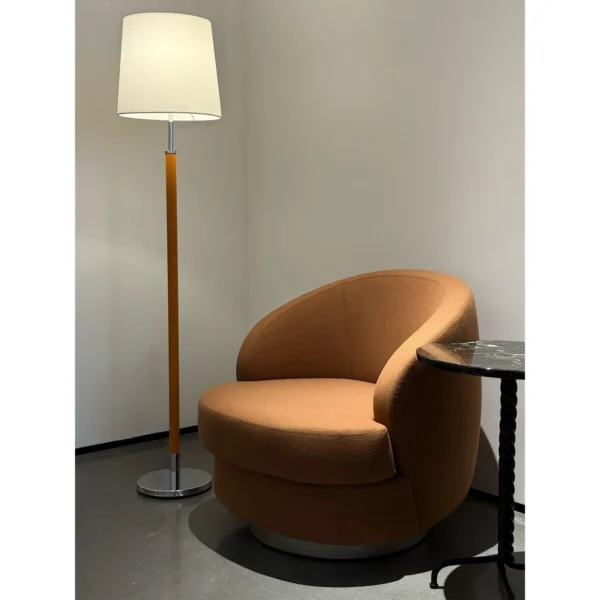 Curved Caramel Fabric Swivel Lounge Chair on Slim Base in rust — in a room setting