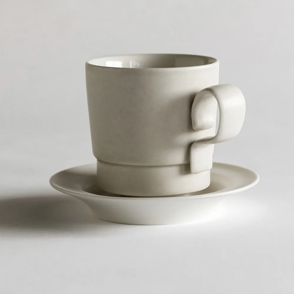 Artist Collaboration Straw-White Ceramic Coffee Cup in oatmeal — front view