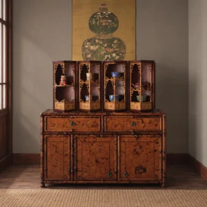 Round Folding Bamboo Treasure Cabinet with Jade Ring Pulls in clay — in a room setting