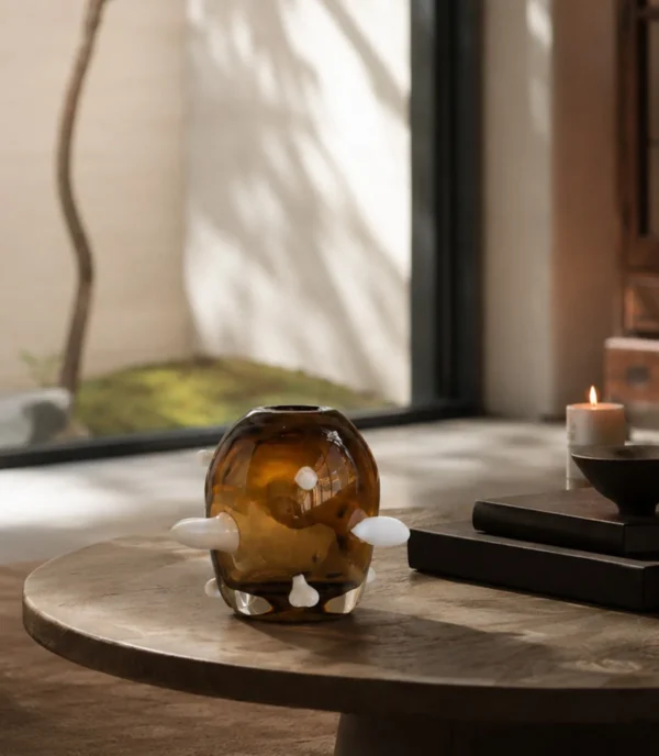 Sculptural Amber Glass Vase with Pale Studs in clay — in a room setting