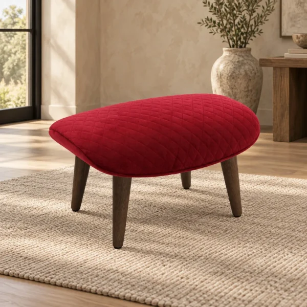 Red Quilted Velvet Footstool with Tapered Wood Legs in red — in a room setting