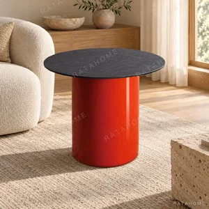 Orange Cylinder Side Table with Black Stone Top in rust — in a room setting