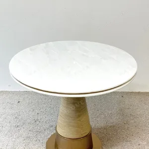 White Stone Round Table on Textured Brass Cone Base in ivory — in a room setting
