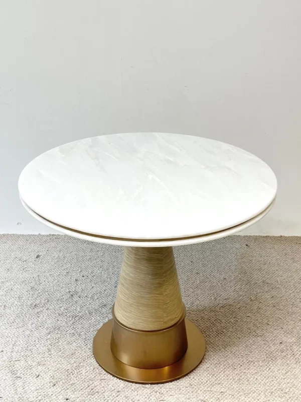 White Stone Round Table on Textured Brass Cone Base in ivory — in a room setting