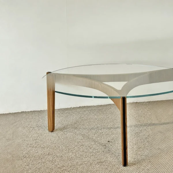 Clear Glass Coffee Table on Walnut Triangular Base in walnut — in a room setting