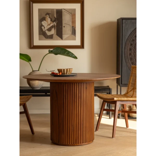 Mango Wood Round Dining Table on Fluted Drum Base in clay — in a room setting