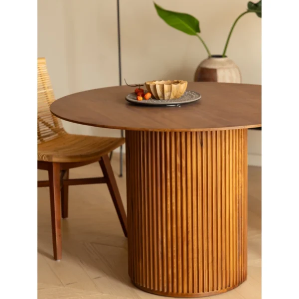 Mango Wood Round Dining Table on Fluted Drum Base in clay — in a room setting