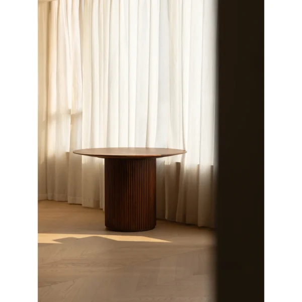 Mango Wood Round Dining Table on Fluted Drum Base in clay — in a room setting