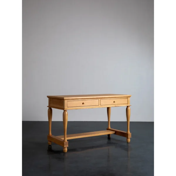 Solid Wood Writing Desk with Turned Legs and Two Drawers in natural oak — in a room setting