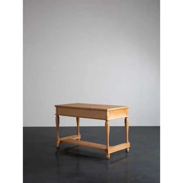 Solid Wood Writing Desk with Turned Legs and Two Drawers in natural oak — in a room setting