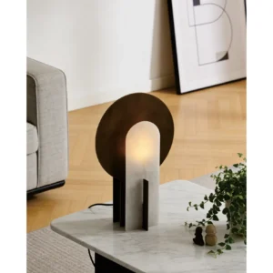 Stone Arch Table Lamp with Black Metal Disc in sand — in a room setting