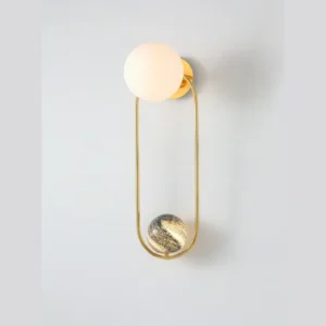 Brass Loop Wall Light with Opal Globe and Marbled Sphere in brushed brass — in a room setting