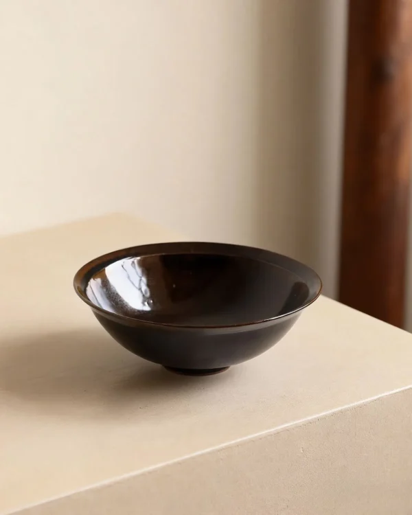 Artist Collaboration Black Glaze Conical Bowl in black — in a room setting