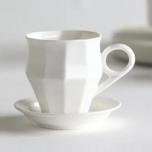 Artist Collaboration Faceted White Ceramic Coffee Mug in ivory — front view