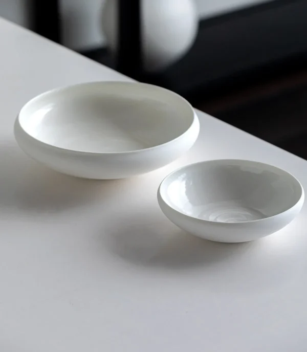 Artist Collaboration Plain Flat Round Shallow Bowl, Small in ivory — in a room setting