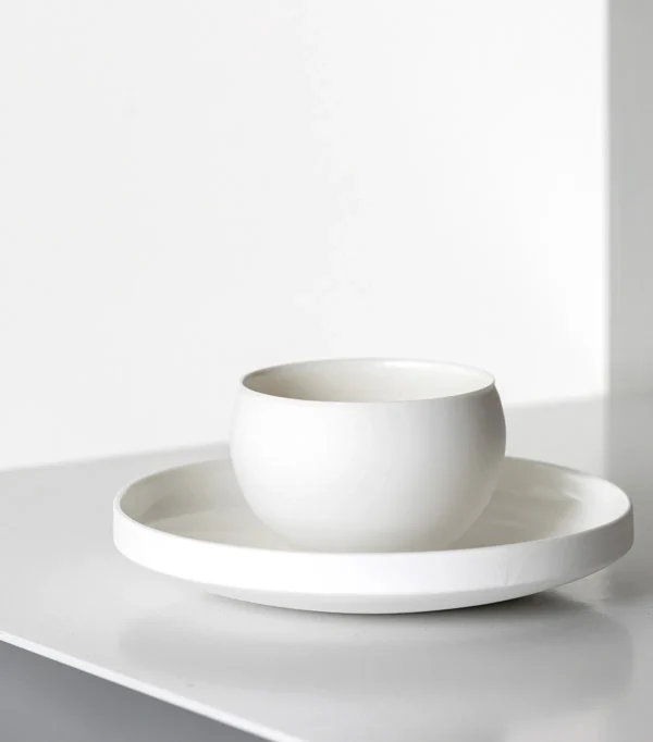 Artist Collaboration Soft-Glow White Porcelain Bowls and Cup in ivory — in a room setting