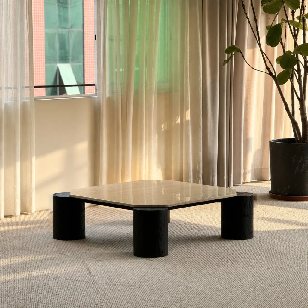 Super White Travertine Coffee Table on Black Cylinder Legs in oatmeal — front view
