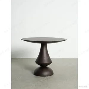 South American Teak Sculpted Pedestal Table in clay — in a room setting