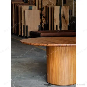 Burmese Teak Round Dining Table on Fluted Drum Base in natural oak — in a room setting