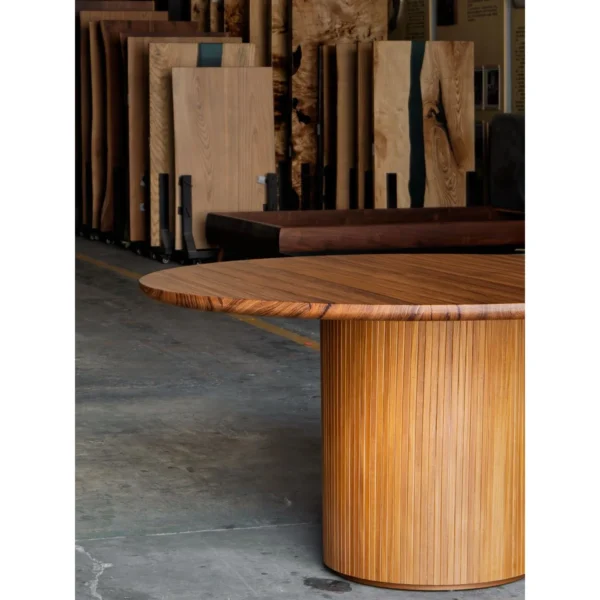 Burmese Teak Round Dining Table on Fluted Drum Base in natural oak — in a room setting