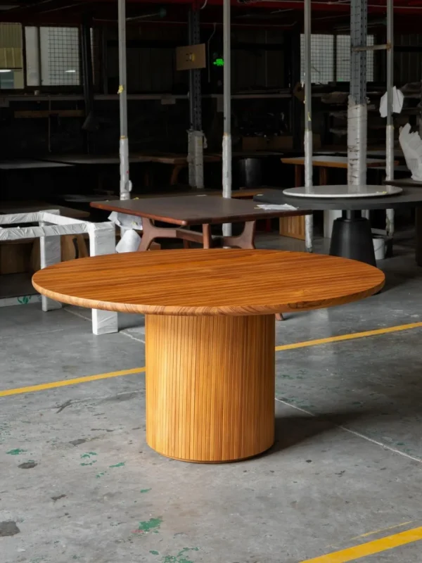 Burmese Teak Round Dining Table on Fluted Drum Base in natural oak — in a room setting