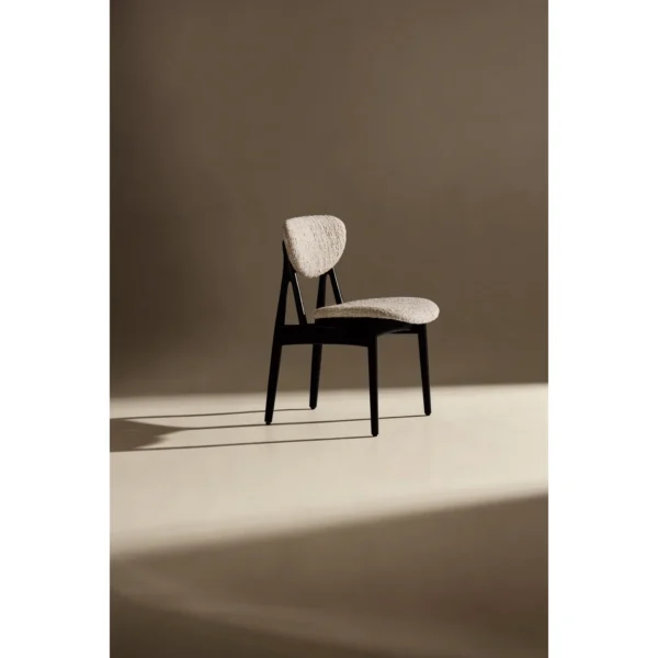Leila Black Ash Dining Chair with Bouclé Cushions in black — in a room setting