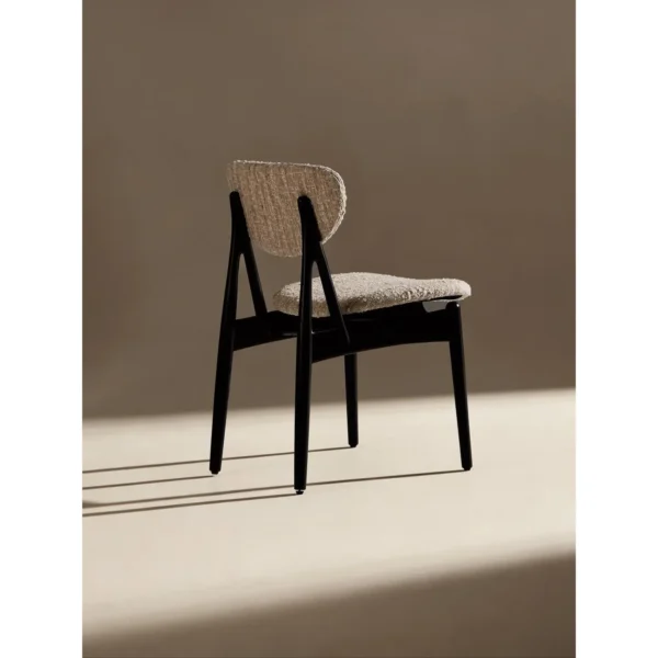 Leila Black Ash Dining Chair with Bouclé Cushions in black — in a room setting