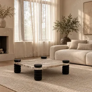 Square Travertine Coffee Table on Stacked Black Stone Legs in sand — in a room setting