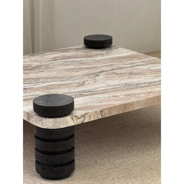 Square Travertine Coffee Table on Stacked Black Stone Legs in sand — in a room setting