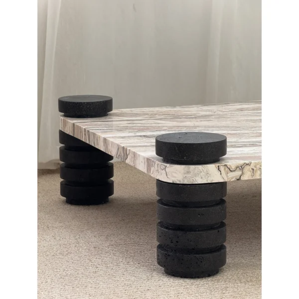 Square Travertine Coffee Table on Stacked Black Stone Legs in sand — in a room setting