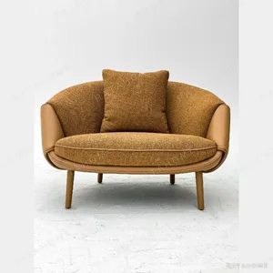 Caramel Two-Tone Leather and Fabric Curved Lounge Chair in clay — in a room setting