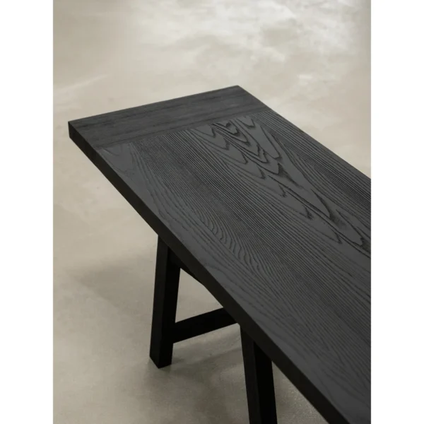 Ubud Black Wood Bench with Crossed Legs in black — in a room setting
