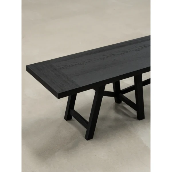 Ubud Black Wood Bench with Crossed Legs in black — in a room setting