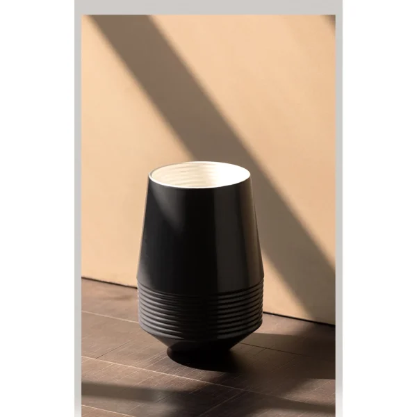 Black Ribbed Cone Ceramic Vase with White Interior in black — in a room setting