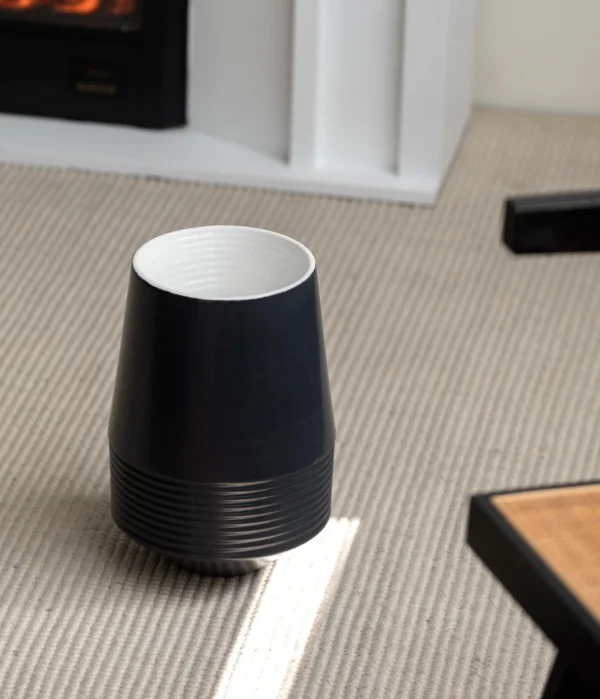Black Ribbed Cone Ceramic Vase with White Interior in black — in a room setting