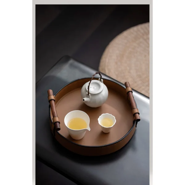 Round Tan Leather Tray in clay — in a room setting