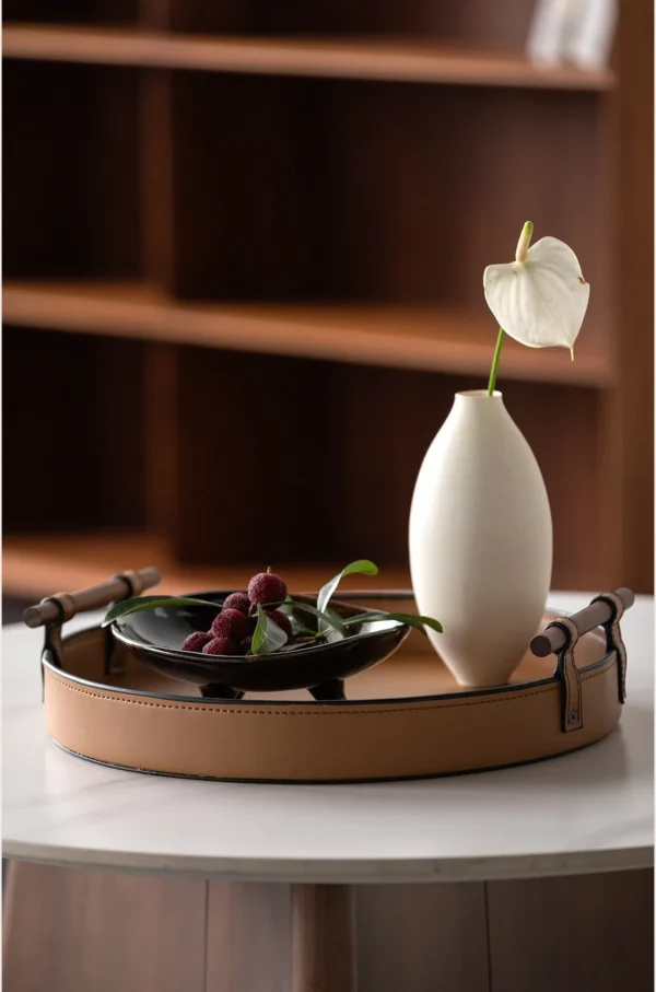 Round Tan Leather Tray in clay — in a room setting