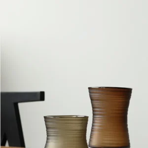 Brown Ribbed Frosted Glass Vase on Dark Foot, Short or Tall in clay — in a room setting