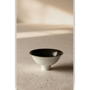 Hand-Made Footed Dessert Bowl in Cream and Black Glaze — in a room setting
