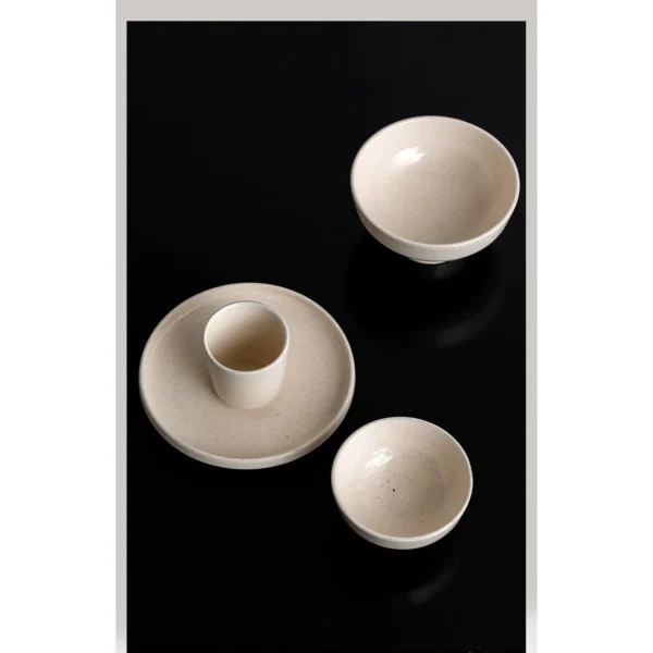 Sand-Cream Stoneware Footed Bowls in oatmeal — in a room setting
