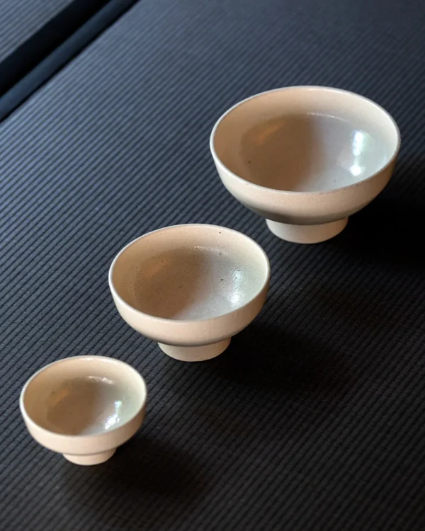 Sand-Cream Stoneware Footed Bowls in oatmeal — in a room setting
