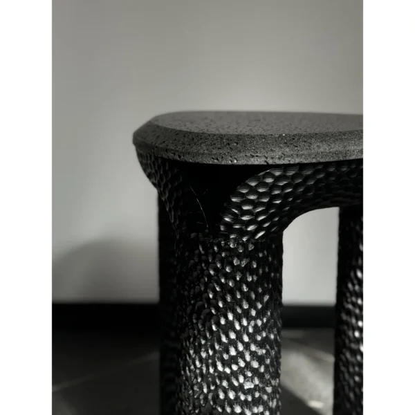 Volcanic Stone Side Table with Scaled Sculpted Legs in black — in a room setting