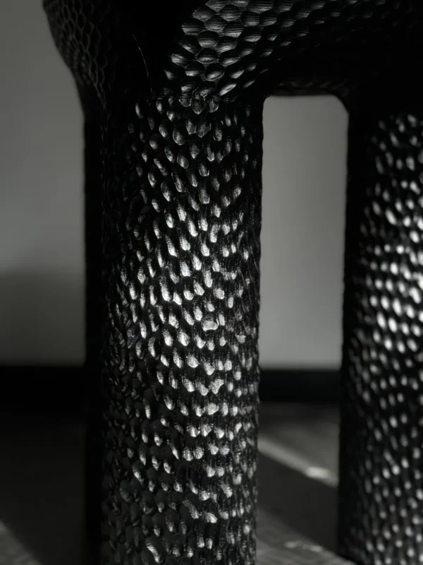 Volcanic Stone Side Table with Scaled Sculpted Legs in black — in a room setting