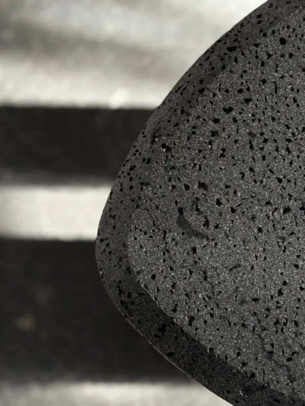 Volcanic Stone Side Table with Scaled Sculpted Legs in black — in a room setting