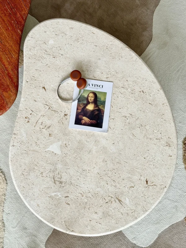 Curved Travertine Coffee Table on Dark Walnut Cylinder Base in oatmeal — in a room setting