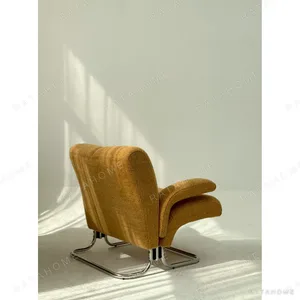 Warm Orange Bouclé Cantilever Lounge Chair on Chrome Frame in rust — in a room setting