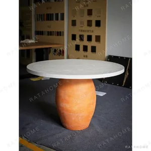 Terracotta Urn-Base Round Dining Table in rust — in a room setting